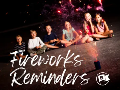Kids sitting on the concrete watching a firework display