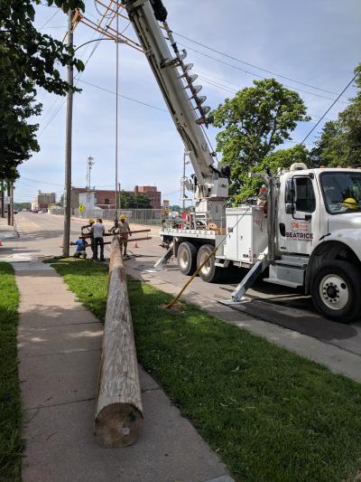Workers replacing electric pole