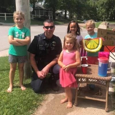 Officer McCormick with children at lemonade stand
